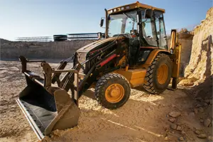 Backhoe loader at a job site supported by mobile fuel delivery in Austin